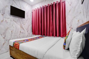 A bedroom with a bed, a TV, and a red curtain. - Fabhotel Comfort Zone (Mumbai)