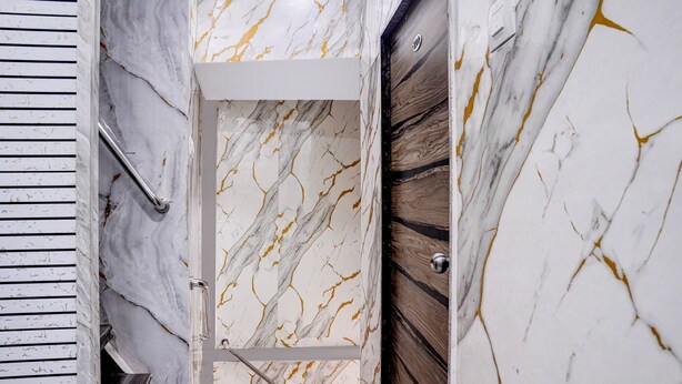 A marble wall with a door, a wooden panel, and a metal handle. - Fabhotel Comfort Zone (Mumbai)