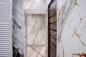 A marble wall with a door, a wooden panel, and a metal handle. - Fabhotel Comfort Zone (Mumbai)