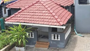 A building with a red tiled roof, a small porch with steps, and a potted plant in the foreground. - FabHotel Prime Plaza Inn - 800M From Calangute Beach (Calangute)