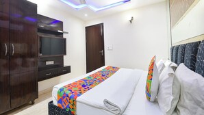 A hotel room with a bed, a wardrobe, a ceiling fan, and a TV. - FabHotel Dev Palace II - Nr Ashok Vihar (New Delhi)