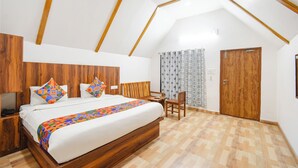 A bedroom with a wooden bed, a desk, a chair, and a door. - Fabhotel Sunshine (Yadagirigutta)