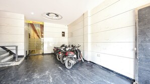 Ein Flur mit einer Reihe geparkter Motorräder, einer Treppe und einem 'Welcome'-Schild.