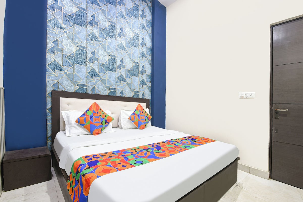 Una cama con colcha de diseño geométrico, un cabecero y dos almohadas con un diseño similar.