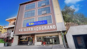 Un edificio de varios pisos con un cartel que dice 'fabHOTELS' y 'SRINIVASA GRAND'.