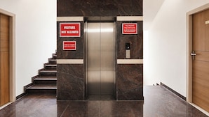 Ein Aufzug mit einem Schild, auf dem 'Besucher nicht erlaubt' steht, und einem weiteren Schild mit Check-in- und Check-out-Zeiten.