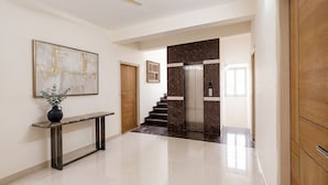 Ein modernes Interieur mit einer Marmortreppe, einem Deckenventilator und einem minimalistischen Design.
