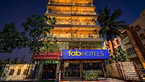 Ein mehrgeschossiges Gebäude mit einem gut sichtbaren Schild mit der Aufschrift 'fab hotels'.