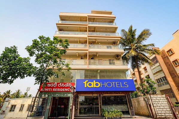 Un edificio de varios pisos con un cartel que dice 'fab hotels' y otro cartel que indica 'Athiti Residency'.