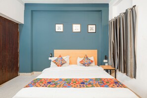Une chambre à coucher avec un lit, une table de chevet et une étagère fixée au mur.