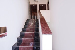 Una escalera con baldosas rojas y negras alternadas que conduce a una plataforma.