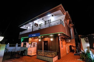 A two-story building with a reception area, outdoor seating, and a balcony.