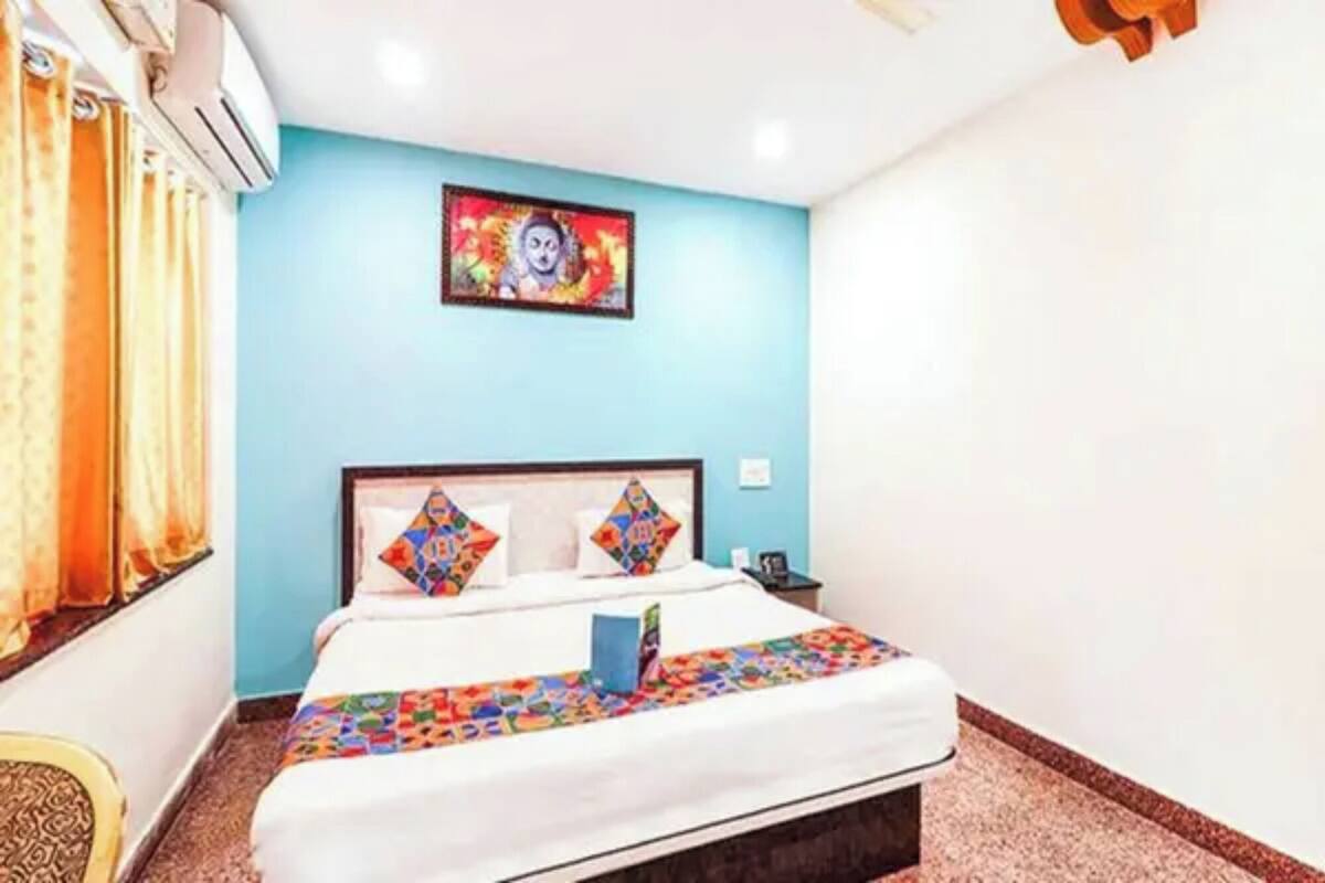 Quarto com cama, cortinas, pintura na parede e ventilador de teto.