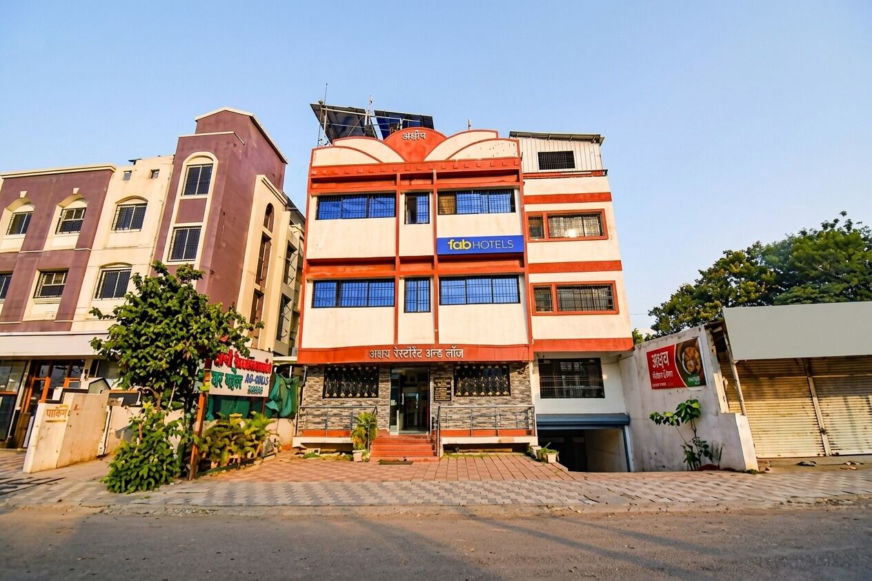 A multi-story building with a sign for 'Fabi Hotels' and another sign for 'Aashirvatt Restaurant and Lounge'.