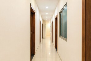 Un pasillo con puertas de madera y un cuadro en la pared.