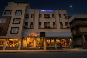 A hotel named 'Le Sancy' with a modern facade, multiple balconies, and a visible restaurant at ground level. - Fabhotel Le Sancy (New Delhi)