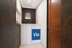 Tauleller de recepció amb un senyal que diu 'Recepció' i un altre que indica 'Comfort Stay' i un horari d'entrada a les 10:00.