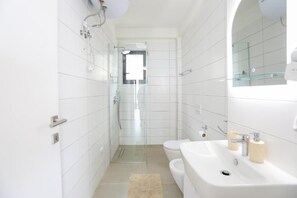 Căn hộ, ban công, quang cảnh biển | Phòng tắm | Buồng tắm vòi sen, dép đi trong nhà 