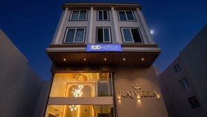 Un edificio con un cartel que indica 'fabHOTELS' y 'RAJVILLE' en la fachada.