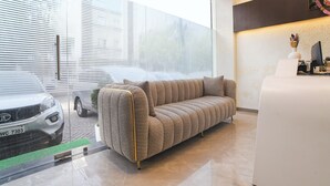 Un interior moderno con un sofá, una recepción y un coche estacionado afuera.