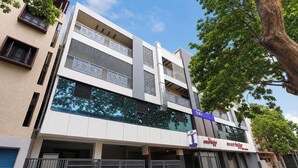 A modern hotel with a flat facade, large windows, and a blue sign indicating it is a hotel. - FabHotel MR Guest Line - Banashankari (Bangalore)