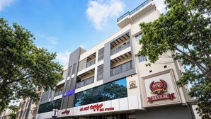 A multi-story building with a modern architectural design, featuring a prominent sign for 'MR GUESTLINE' and a 'BAR ATTACHED' sign. - FabHotel MR Guest Line - Banashankari (Bangalore)