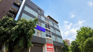 A multi-story hotel with a blue and grey facade, air conditioning units on the exterior, and a sign for 'AMAR RESIDENCY.' - Fabhotel Amar Residency (New Delhi)