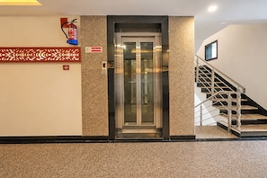 An elevator with a glass door, a 'No Smoking' sign, and a fire extinguisher on the wall. - FabHotel Pratibha Grand - near Vijayawada Junction (Vijayawada)