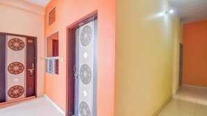 A hallway with two doors, one with a circular pattern and another with a geometric design. - Fabhotel Radhy Stay (Jaipur)