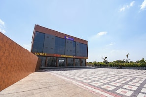 Un edificio moderno con un letrero que indica 'FabHotels' y 'DSP Restaurant'.