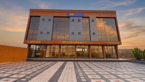 Um edifício com a placa 'fab hotels', 'Lodge', 'DSP Restaurant' e sinalização 'Datataguru Enterprises'.