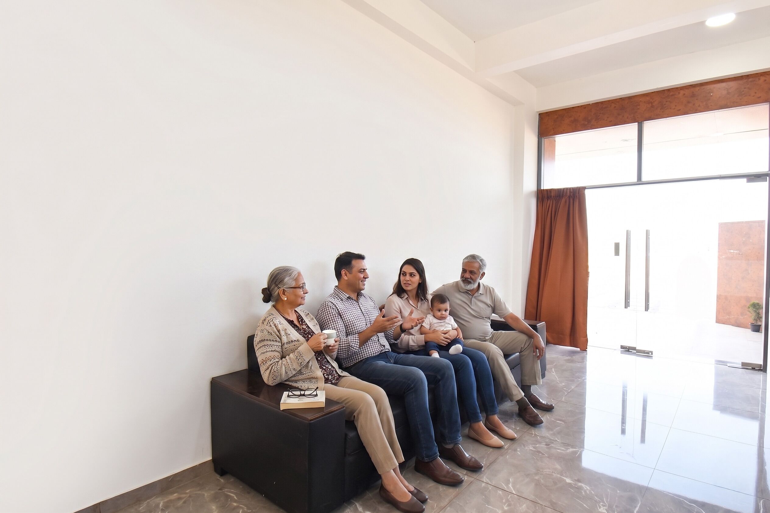A group of people seated on a bench in a room with a tiled floor and a large window.