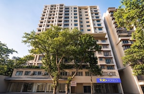 A multi-story building with balconies, air conditioning units, and a sign for 'fabHOTELS.' - Fabhotel Byland International (Mumbai)