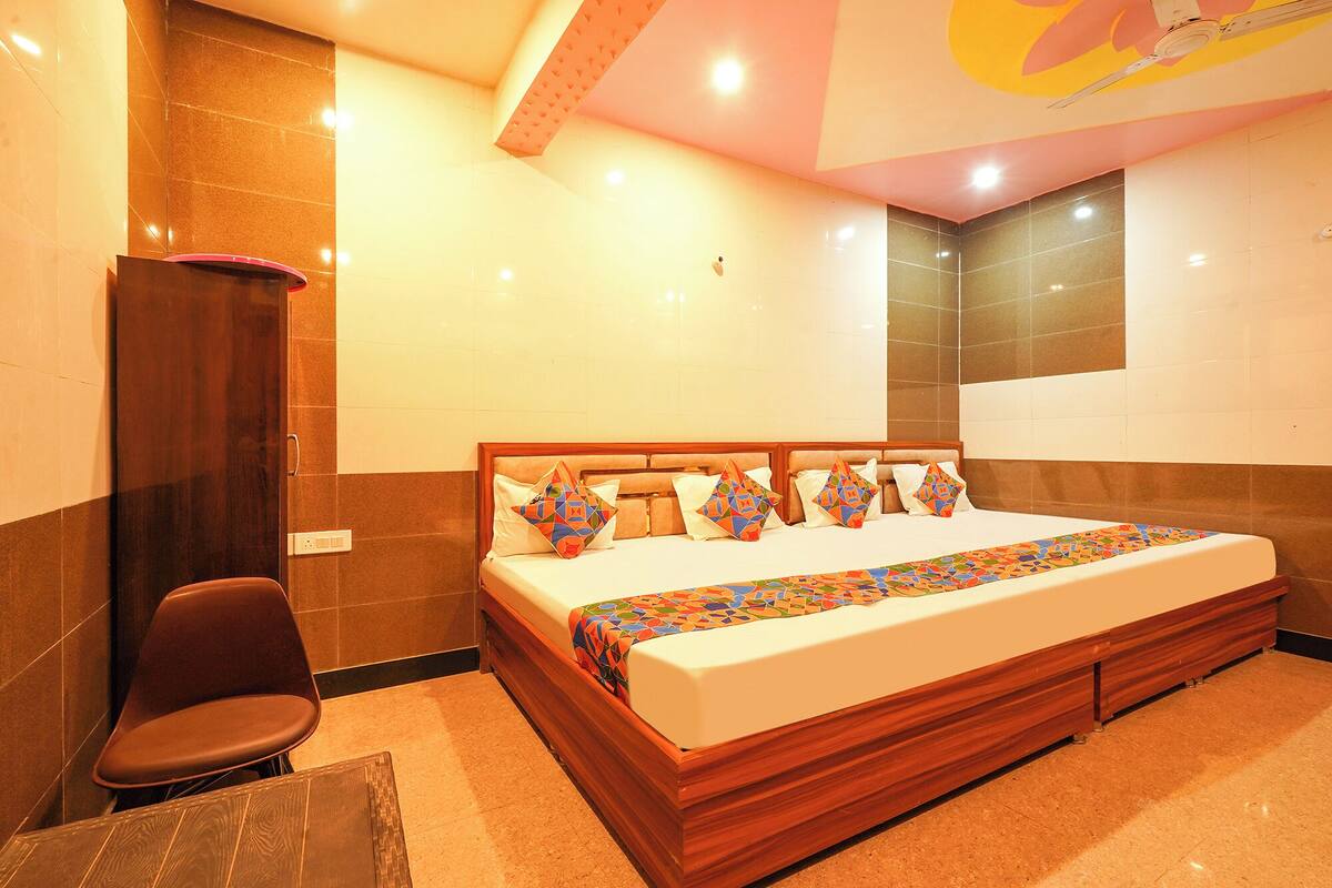 Ein Hotelzimmer mit einem großen Bett, einem Holzkopfende, einem Schreibtisch und einem Stuhl.
