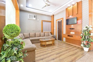 Olohuoneessa on sohva, sohvapöytä, televisio ja puinen kaappi.