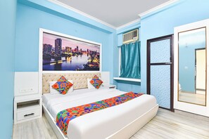 A bedroom with a bed, a window with curtains, a wall-mounted air conditioner, and a cityscape painting.