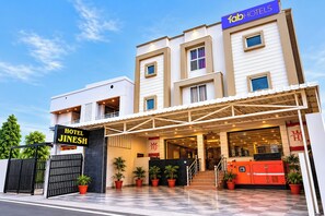 A modern hotel with a prominent entrance, a covered walkway, and a sign for 'Hotel Jinmesh.'
