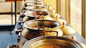 Een buffet met verschillende bakken vol eten.