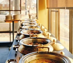 A buffet line with multiple food containers.