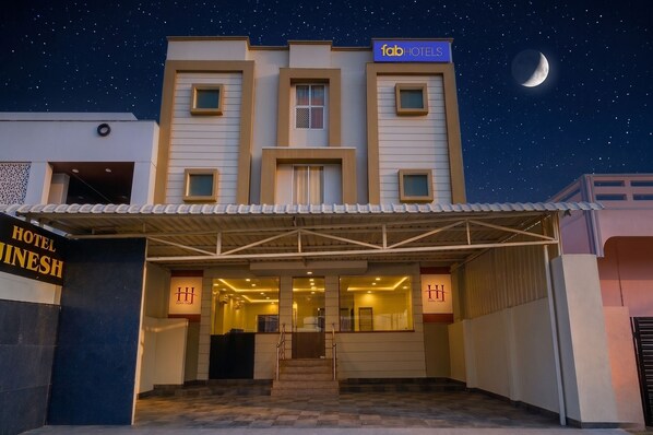 Entrada de hotel con un cartel que dice 'fab hotels' y 'Hotel Inesh'.