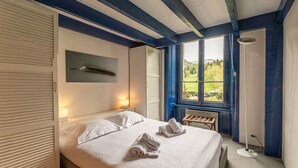 A bedroom with a bed, two bedside lamps, a window with a view, and a bedside table. - SmartStay Planet - Argentière (Argentière)