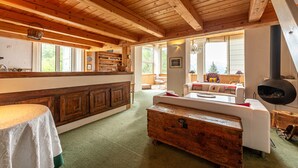 A rustic interior with wooden beams, a kitchen area, a sofa, and a fireplace. - SmartStay Planet - Argentière (Argentière)