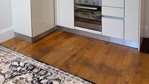 Eine moderne Küche mit weißen Schränken, einem eingebauten Backofen, einer Mikrowelle und einem Gasherd.