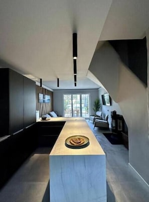 A modern kitchen with a central island, recessed lighting, and a view to a dining area. - Casa iKa Port Grimaud - Fishing houseeur 4 Rooms with mooring (Grimaud)