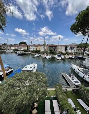 A marina with boats docked, a clear sky, and residential buildings in the background. - Casa iKa Port Grimaud - Fishing houseeur 4 Rooms with mooring (Grimaud)