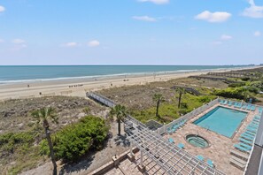 Blick auf einen Strand mit Poolbereich, einschließlich Whirlpool und Liegestühlen.