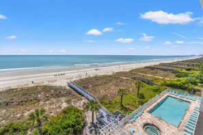 Ein Strandresort mit Schwimmbad, einer Promenade und Blick auf den Ozean.