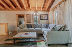 A cozy living room with a sectional sofa, a coffee table, and a wooden ceiling. - The Golden Bend Cozy Stay (Truckee)
