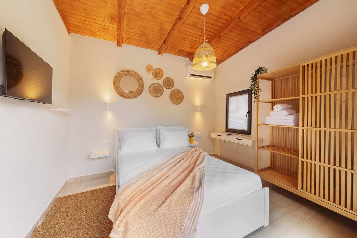 Une chambre moderne avec un lit, une télévision, une armoire en bois et des éléments de décoration murale.