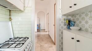A kitchen with a gas stove, white cabinets, and a tiled backsplash. - Cozy 57m2 apartment, ideal for 3 people, located on the fifth floor of a building with lift.The property is located in the Navigli area, one of the areas most loved by citizens and tourists, in a context full of services. The location is also ideal for r (Milan)